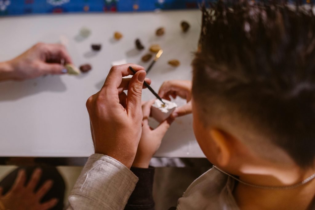 Engaging Curriculum-Inspired Activities - Photo of Child doing art and craft project with their parent